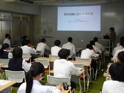 本センターの教員がプロジェクターで「探究活動における考え方」というプレゼンテーションのタイトルを表示して解説を行っている